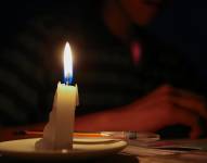 Un estudiante lee un texto a la luz de una vela en Quito.