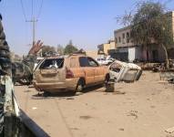 Un soldado del ejército sudanés hace un gesto desde la parte trasera de un vehículo mientras este pasa junto a vehículos dañados en una calle de Jartum, el 2 de abril de 2025.