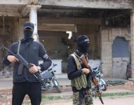 Miembros de seguridad sirios hacen guardia cerca de edificios dañados un día después de que un ataque aéreo israelí golpeara la ciudad de Deraa, en el sur de Siria, el 18 de marzo de 2025.
