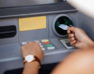 Imagen referencial de una persona retirando dinero de un cajero automático.