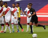 El árbitro Esteban Ostojich yendo a revisar el VAR.