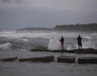 Dos personas pescan en la playa hoy, mientras el país se prepara para el paso en las próximas horas del huracán Fiona, en Nagua (República Dominicana)