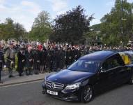 Ciudadanos en Ballater, Escocia, al paso del auto fúnebre de la reina Isabel II en su recorrido desde Balmoral a Edimburgo, en Escocia, el sábado 11 de septiembre de 2022. (Andrew Milligan/PA via AP)