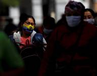 Personas con mascarilla caminan por una calle en la ciudad de Quito (Ecuador), en una fotografía de archivo. EFE/José Jácome