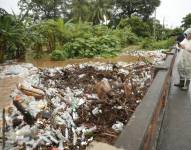Un hombre observa desechos acumulados por el desborde de un río, este martes en Metalío (El Salvador). EFE/ Rodrigo Sura