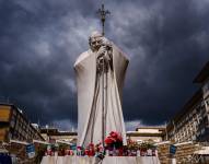 Velas y flores junto a la estatua de Juan Pablo II a las puertas del hospital Gemelli, donde el Papa Francisco está ingresado por una neumonía, en Roma, el 27 de febrero de 2025.