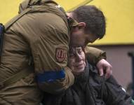 Un soldado consuela a Larysa Kolesnyk, de 82 años, después de que fuera evacuada de Irpín