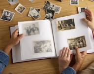 Imagen referencial de personas mirando álbum de fotos.