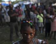 Una niña espera con otras víctimas del sismo de magnitud 7,2 que sacudió Haití la semana pasada en un centro de distribución de alimentos en Les Cayes, el sábado 21 de agosto de 2021.
