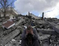 Una mujer sentada sobre los escombros de un edificio que se derrumbó por el sismo del lunes en Nurdagi, sur de Turquía, el martes 7 de febrero.