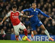 Piero Hincapie en una jugada ante Joao Pedro durante el duelo Arsenal vs. Chelsea.