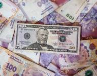 Fotografía de archivo de billetes de dólares y pesos argentinos en Buenos Aires, Argentina