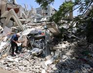 Hisham Salem, de 70 años, profesor de física y matemáticas, que ahora vive con su esposa en un centro educativo, busca entre los escombros de su casa después de que fuera destruida en el bombardeo israelí.