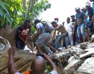 Un grupo de personas sacan el cuerpo sin vida del senador Jean Gabriel Fortuné.