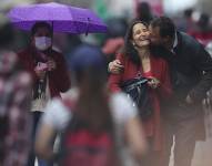 Grupos de personas con y sin mascarillas caminan hoy, por las calles de Quito (Ecuador). José Jácome / EFE / Archivo