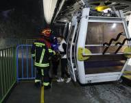 Los bomberos al momento que rescatan a una mujer de una góndola del Teleférico de Quito.