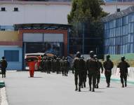 Militares custodian a reclusos mientras se trasladan dentro de la cárcel de Cotopaxi durante un recorrido de la prensa al recinto penitenciario, en una fotografía de archivo.