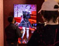 Periodistas entrevistan a la VTuber Mori Calliope, interactuando con ella a través de una interfaz en pantalla que muestra el avatar animado de la intérprete, en una tienda temporal de Hololive en el centro comercial Beverly Center en Los Ángeles, California, el 27 de febrero de 2025.