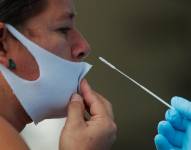 Una mujer se realiza una prueba de hisopado nasal para detectar la covid-19 en un puesto médico.