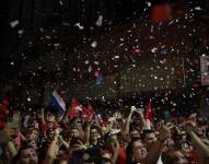 Seguidores del presidente electo del Partido Colorado, Santiago Peña, celebran tras su victoria a las afueras de su sede campaña, hoy en Asunción (Paraguay).