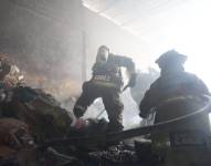 Imagen de bomberos apagando un incendio en el interior de una bodega del sur de Guayaquil, este 11 de septiembre.