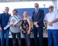 Foto de Stefano Ferretti, vicepresidente de Ambiensa, junto a Eduardo Peña. presidente del Consejo Directivo del IESS, y Humberto Plaza, ministro de Vivienda, entregando la llave de un hogar a una familia en Chongón, Guayaquil