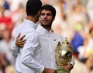 Carlos Alcaraz, posando con el título junto a Novak Djokovic, rival al que derrotó.