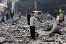 Un niño mira mientras los palestinos se encuentran en medio de la devastación en el patio de una escuela, un día después de que fuera alcanzada por un ataque aéreo israelí, en el barrio de al-Tuffah en la ciudad de Gaza el 4 de abril de 2025.