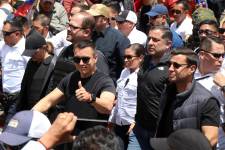 Ecuador's President Daniel Noboa (L) and Interior Minister John Reimberg (L, back) walk wearing bulletproof vests during a march against the Constitutional Court's decision to censor several articles of recent laws in Quito on August 12, 2025. (Photo by Galo Paguay / AFP)