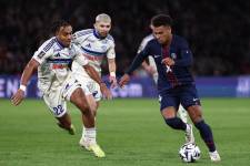 El centrocampista francés del Paris Saint-Germain, Desire Doué (#14) (derecha), y el defensor marfileño del Estrasburgo, Guéla Doué (#22) (izquierda), disputan el balón