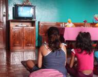 Tres niñas ven televisión en Santo Domingo, en una fotografía de archivo.