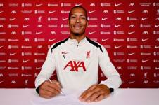 Virgil Van Dijk, firmando su renovación con el Liverpool.