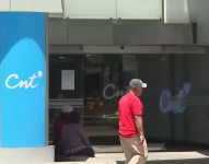 Imagen de una persona pasando al frente de una oficina de CNT en Quito.