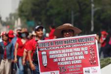Fotografía de archivo del 15 de abril de 2024 de una integrante de la Coordinadora Nacional de Trabajadores de la Educación (CNTE) sosteniendo un cartel durante una manifestación en Ciudad de México (México).