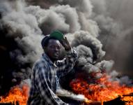 Un hombre camina por una calle en llamas, en Puerto Príncipe (Haití), en una fotografía de archivo.