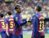 El delantero brasilero del Barça, Raphinha, celebra con su compañero Lamine Yamal tras anotar el primer gol del equipo este domingo, durante el partido de la jornada 17 de LaLiga, que disputaron Villarreal CF y el FC Barcelona en el Estadio de la Cerámica.