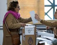 Una mujer recibe el material electoral para su votación en las elecciones primarias hoy, en Buenos Aires, Argentina. Los colegios electorales abrieron a las 08:00 hora local.