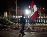 Una persona sostiene una bandera frente a integrantes de la Policía del Perú durante una manifestación en Lima (Perú), en una fotografía de archivo.