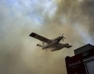 Un avión lanza agua en el incendio de Velestino, Grecia.
