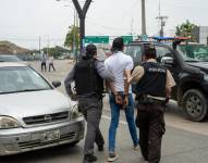 Fotografía de archivo que muestra a policías mientras detienen a un presunto delincuente en Guayaquil.