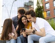 Amigos al aire libre en la ciudad mirando smartphone