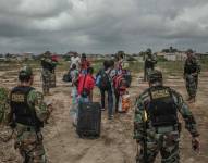Miembros de la policía de Perú controlan el paso de migrantes venezolanos que intentan cruzar la frontera de Perú por la orilla del río Zarumilla, junto a Ecuador.