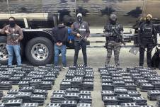 Agentes antidrogas de la Policía Nacional de Ecuador posan con un detenido y el cargamento.