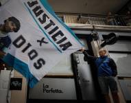 Fotografía de archivo en donde se ven personas con una pancarta de Maradona.