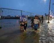 Foto del pasado 20 de febrero, en la que se registró a un grupo de personas al caminar por una vía inundada.