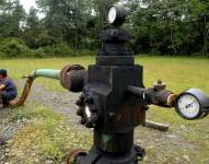 Unos niños indígenas, de la etnia ecuatoriana Cofán, descansan junto a instalaciones petrolíferas abandonadas, en una fotografía de archivo.