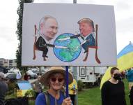 Una mujer sostiene un cartel durante una protesta este jueves, en contra de la reunión prevista entre el presidente de Estados Unidos, Donald Trump, y su homólogo ruso, Vladímir Putin.
