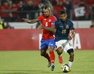 Arturo Vidal (i) de Chile disputa el balón con Pedro Vite de Ecuador en un partido de las Eliminatorias Sudamericanas para el Mundial de 2026