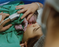 Imagen de archivo de una mujer sosteniendo a su bebé luego de dar a luz.