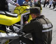 Un perito de Criminalística revisa una motocicleta.